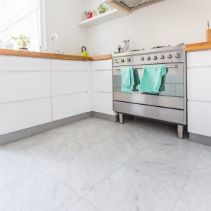 Bianco Carrara Type C Gezoet in keuken. Witte Hoogglans keuken met houten blad.