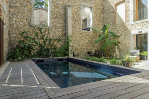 Zwembad in de tuin met een mix van geolied donkerblauw en paars glasmozaïek van Ezarri