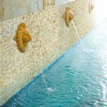 Prachtige leeuwenkop waterspugers in een zwembad van Ezarri glasmozaïek Bellini
