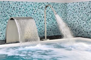 Een binnen zwembad met een mix van azurblauw en lichtgroene glasmozaïek steentjes van Ezarri