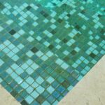 De boden van een buitenzwembad bedekt met groene matjes glasmozaïek van Ezarri