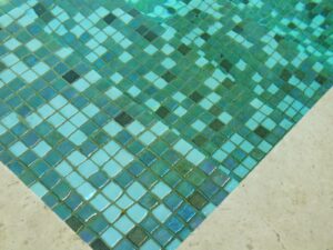 De boden van een buitenzwembad bedekt met groene matjes glasmozaïek van Ezarri