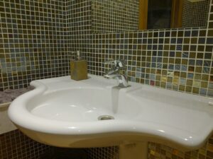 Luxe glasmozaïek matjes in een badkamer verwerkt in de zilver met goud en bruin kleuren